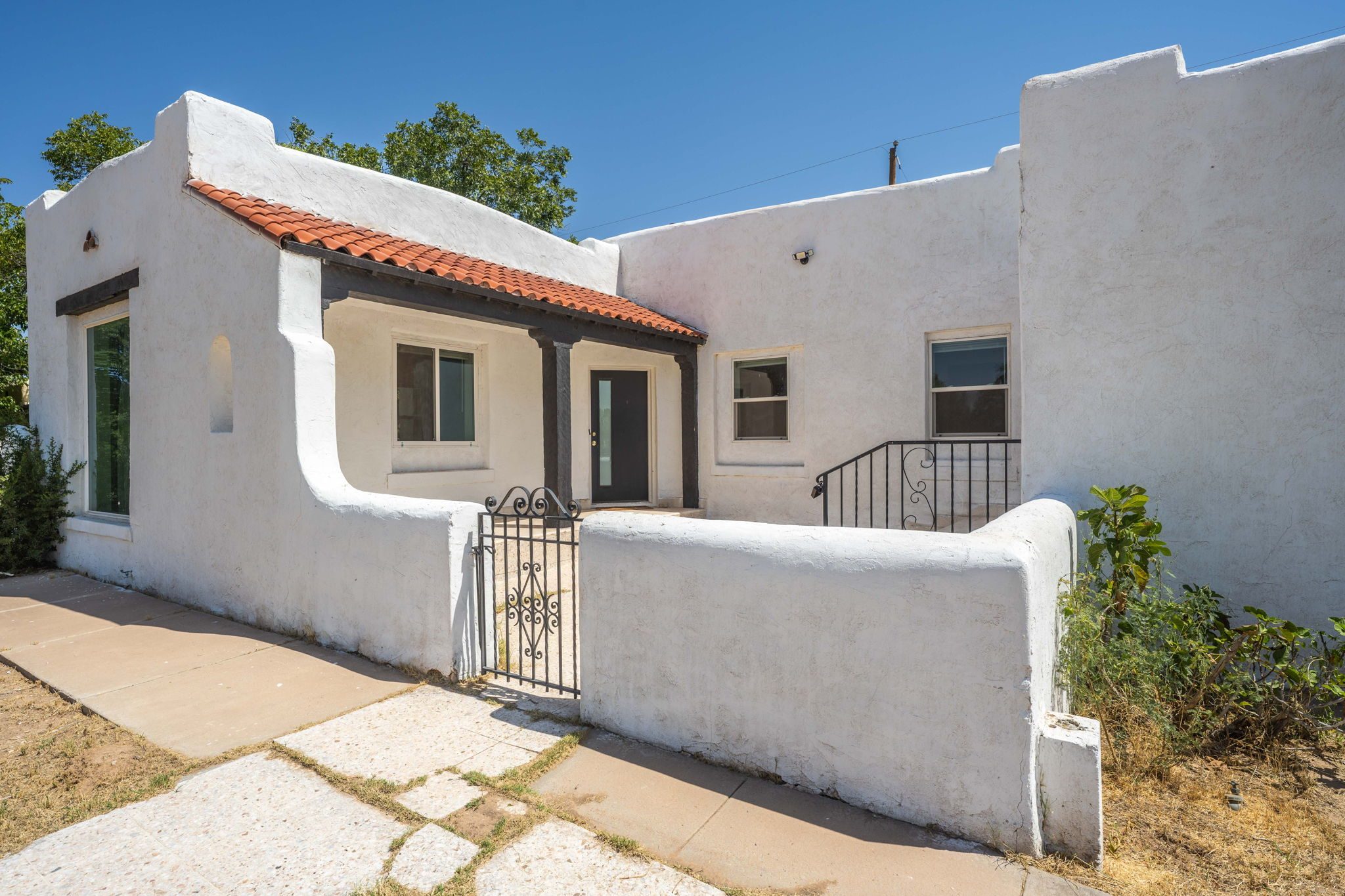 1040 Hess Terrace, a white 1937 adobe with a red tile portal