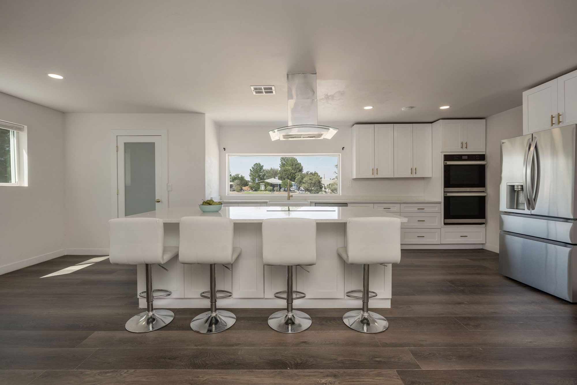 Renovated kitchen with a four-seat island, double wall ovens, and French-door refrigerator