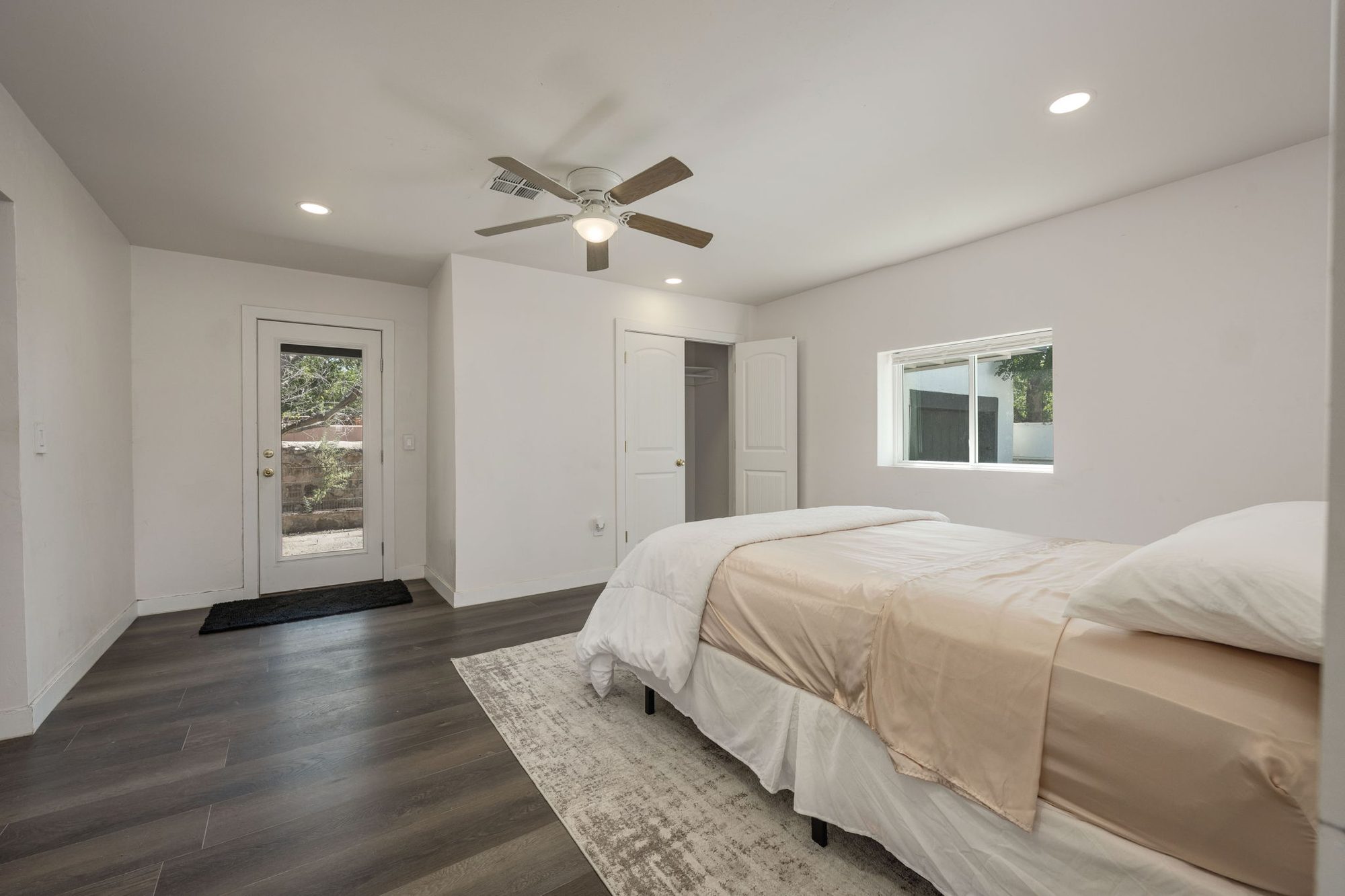 Primary bedroom with its own exterior door, closet, and ceiling fan
