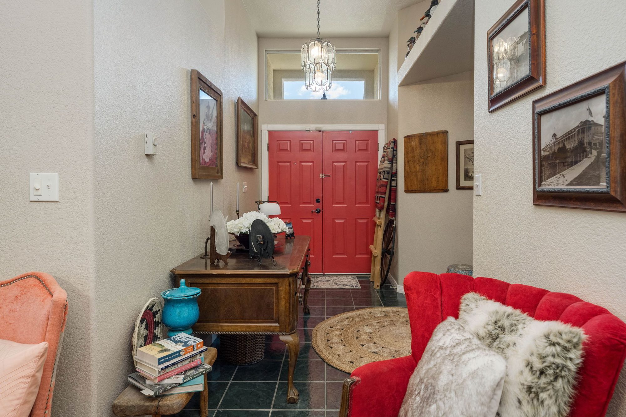 Entry foyer with red double doors and chandelier