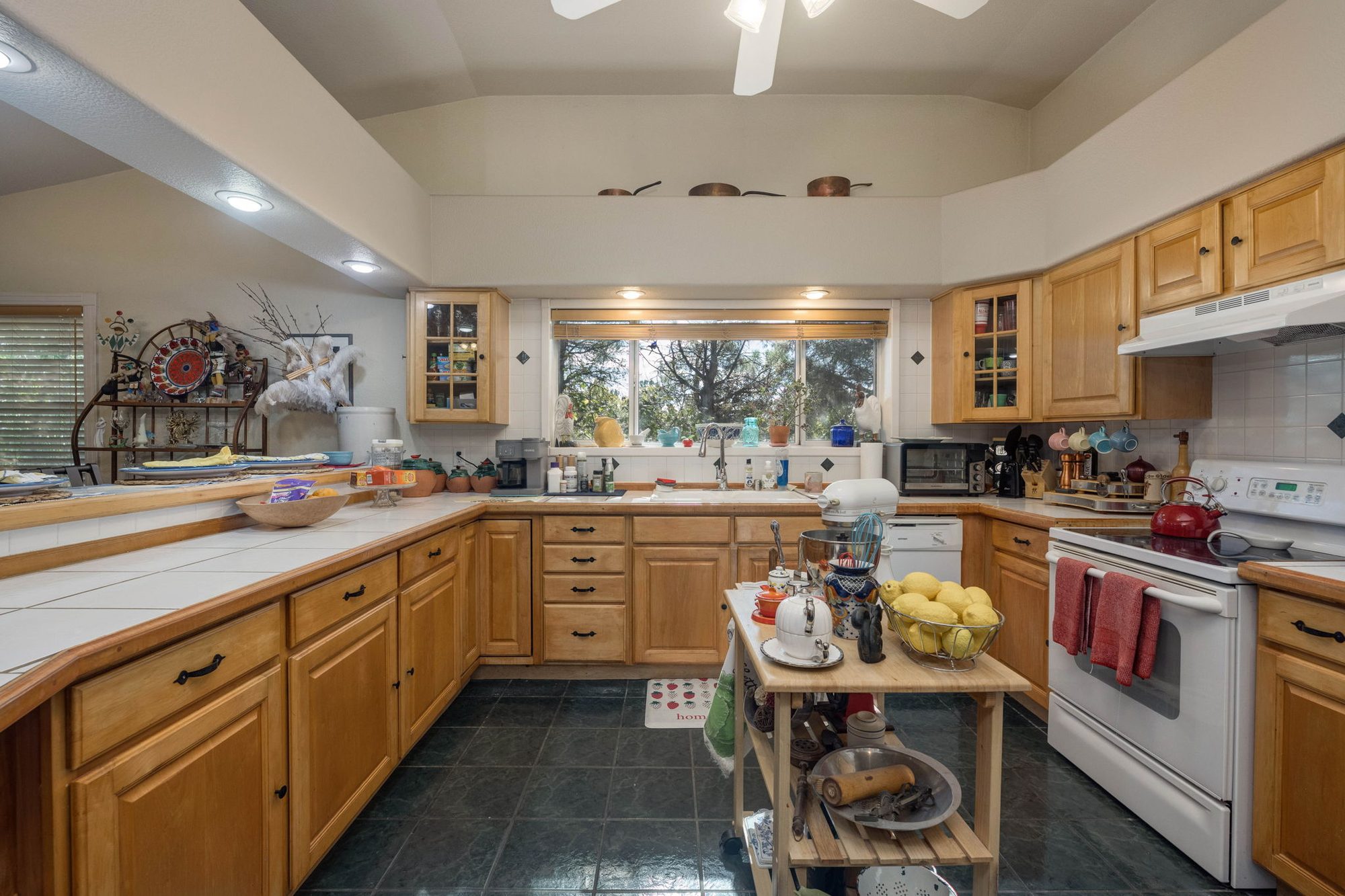 Kitchen with honey-toned cabinetry and tile counters