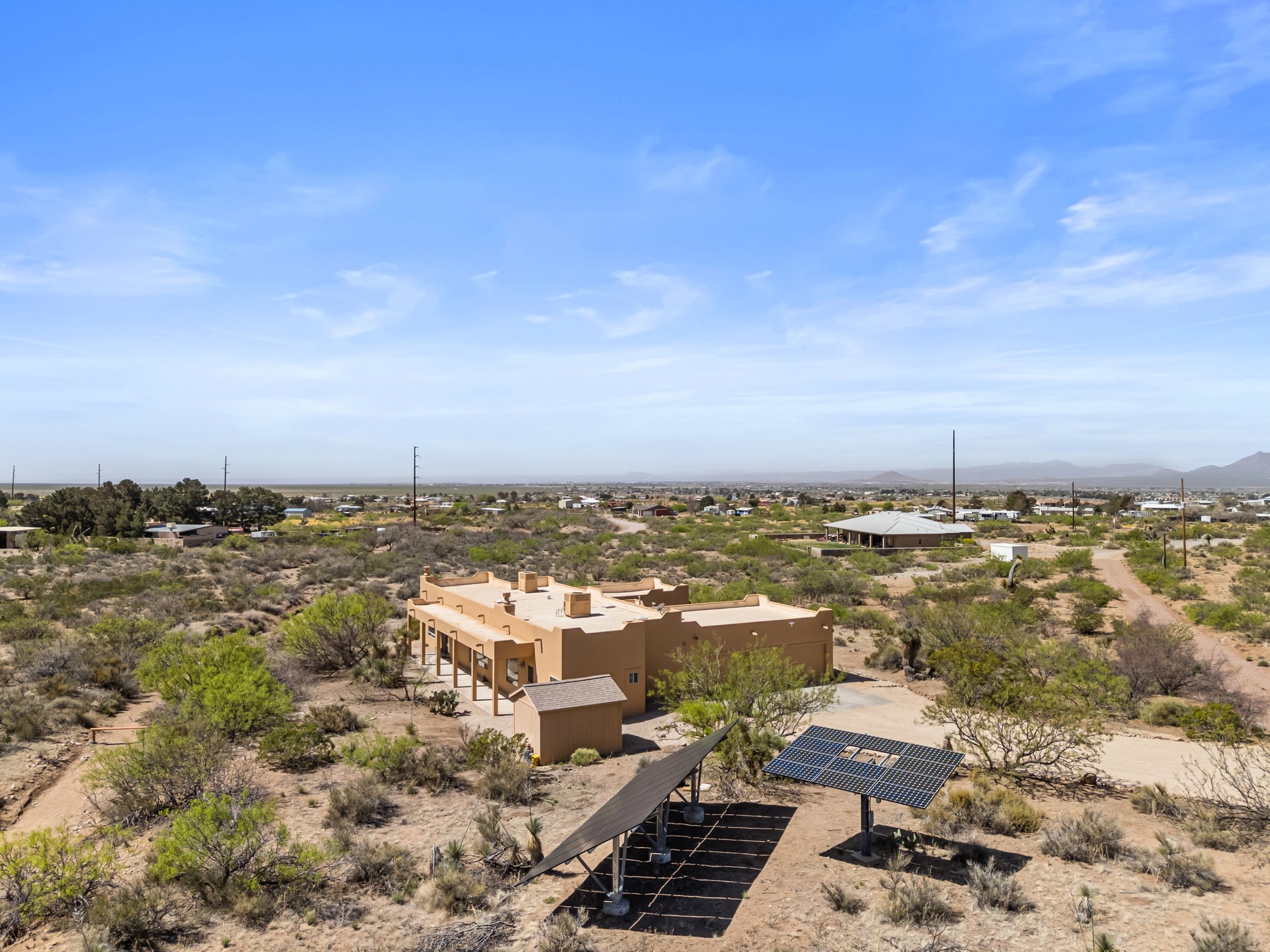 Aerial of the home on five acres with ground-mounted solar array