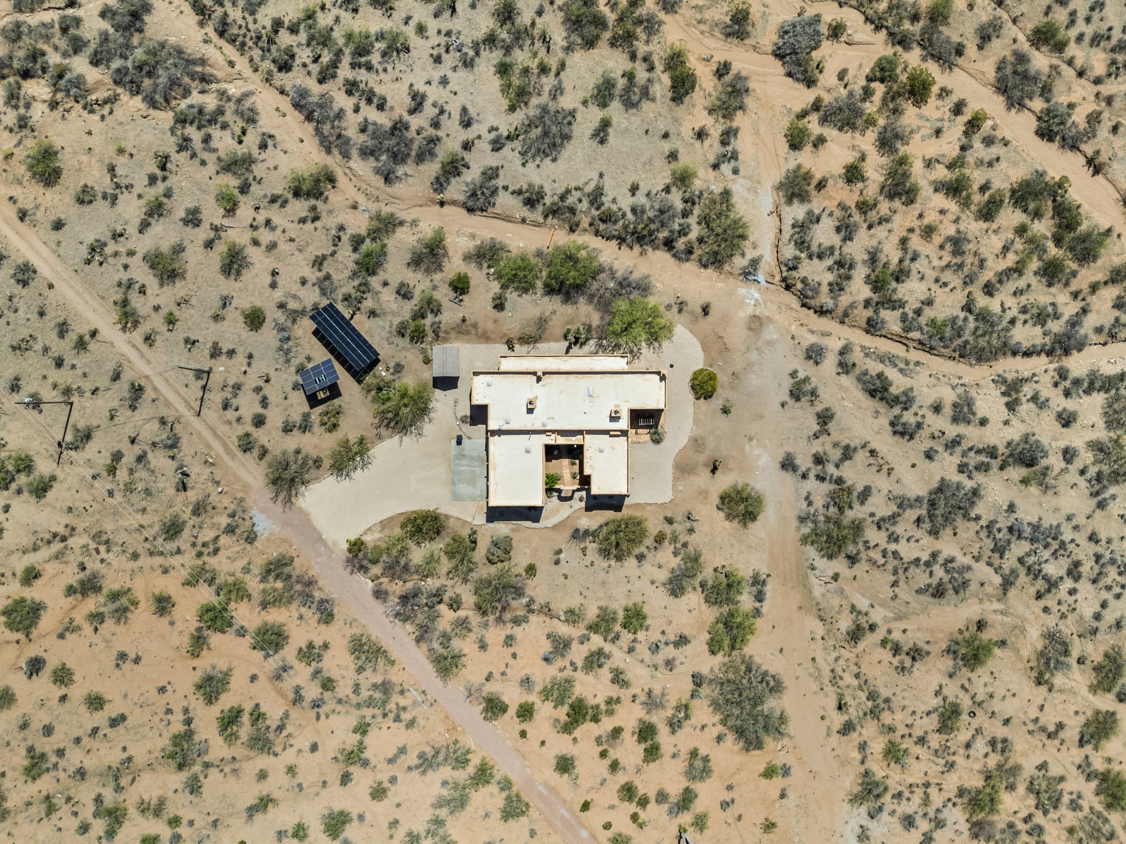 Overhead aerial showing the home and ground-mounted solar array