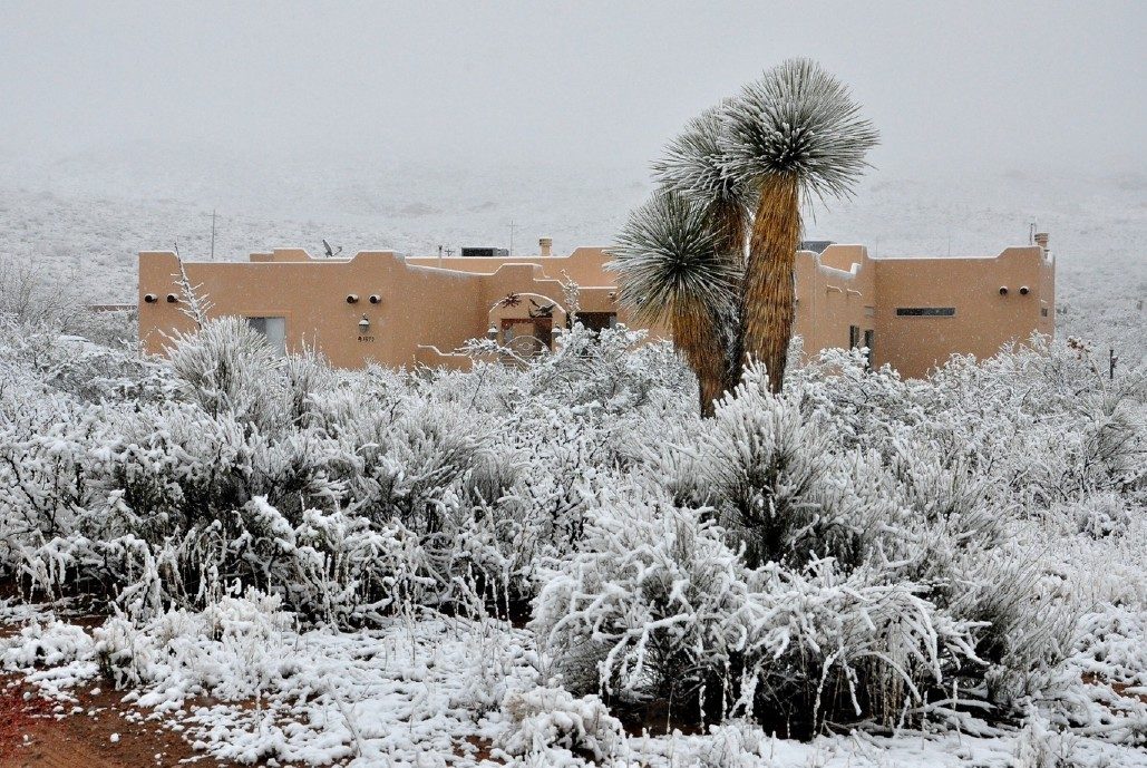 The adobe home under fresh desert snow