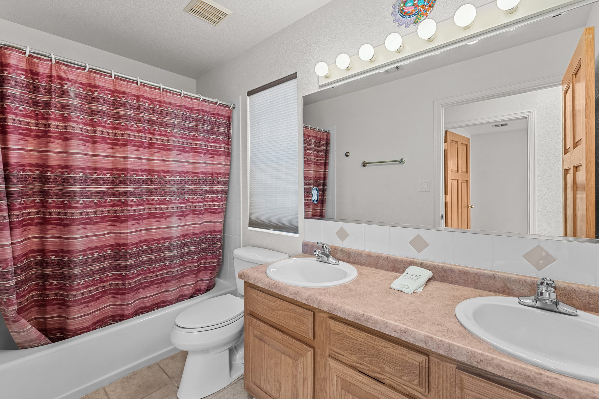 Guest bath with tub-shower and dual-sink vanity