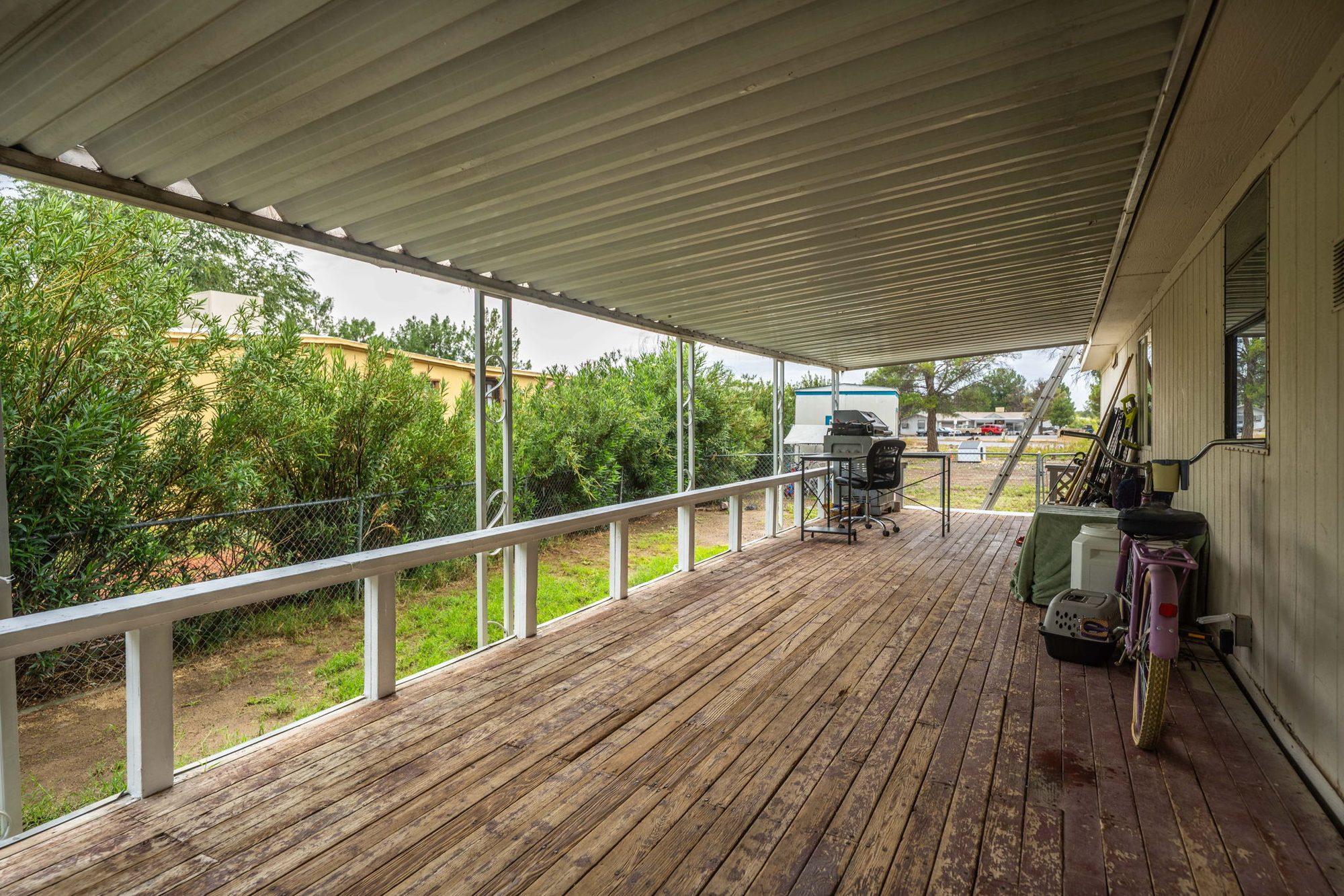 Long covered back deck with white railing